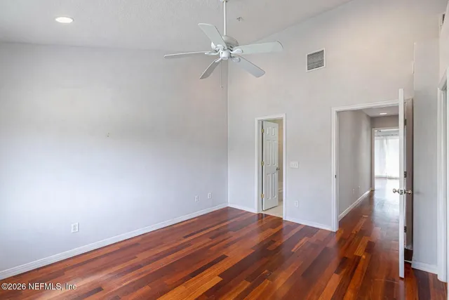 a view of a room with wooden floor and a ceiling fan