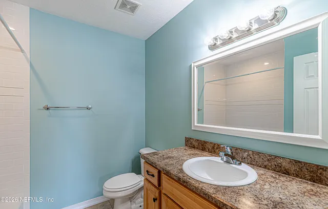 a bathroom with a sink toilet a mirror and vanity