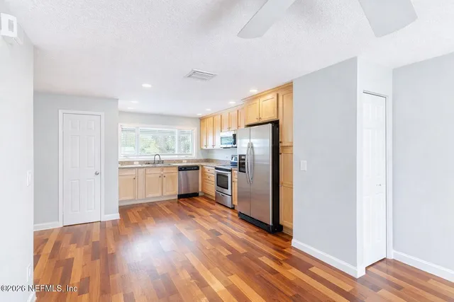a kitchen with a refrigerator a sink and cabinets