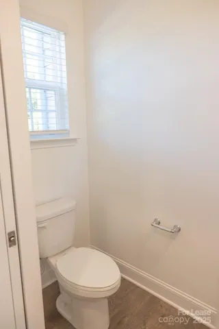 a white toilet sitting next to a window