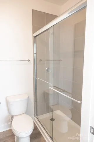 a white toilet sitting next to a shower