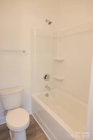 a white toilet sitting next to a bath tub