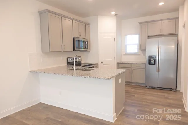 a kitchen with stainless steel appliances granite countertop a sink and a refrigerator