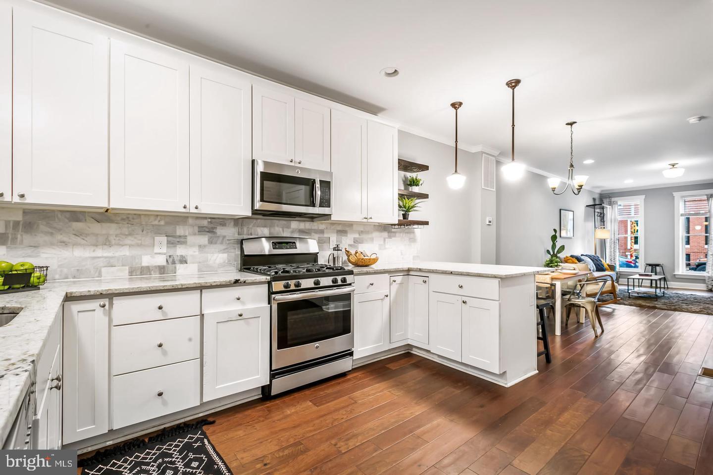 3019 Keswick Road Baltimore, MD 21211 - Photo 4 of 29 a kitchen with cabinets stainless steel appliances a sink and wooden floor