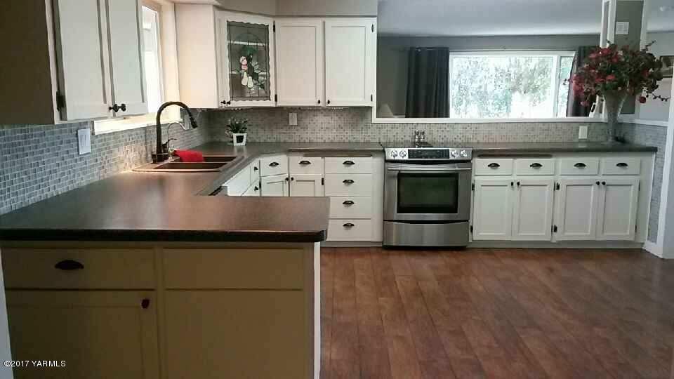 11604 Summitview Ext Road Yakima, WA 98908 - Photo 7 of 41 a kitchen with granite countertop a stove a sink and a microwave