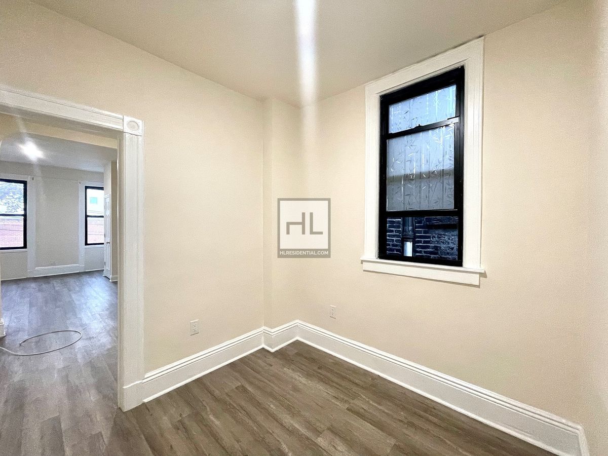 51-28 35th Street, Unit 2 Queens, NY 11101 - Photo 4 of 7 an empty room with wooden floor and windows