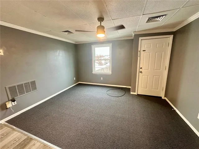 an empty room with windows and ceiling fan