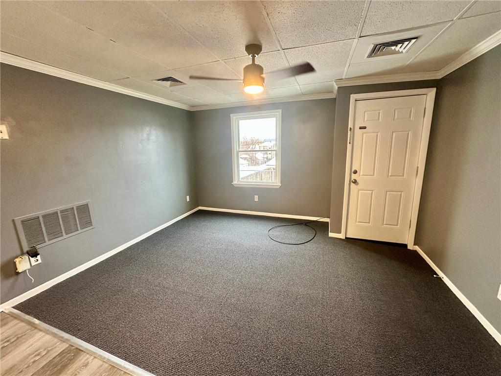 305 Bessemer Avenue, Unit 3B East Pittsburgh, PA 15112 - Photo 2 of 8 an empty room with windows and ceiling fan