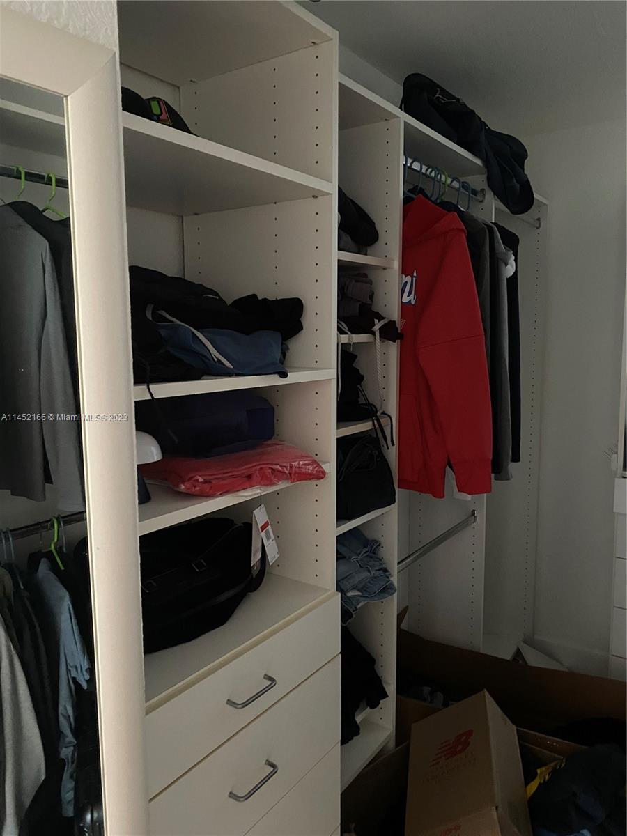 240 Southwest 15th Road, Unit 110 Miami, FL 33129 - Photo 15 of 17 a view of walk in closet with clothes and shoes