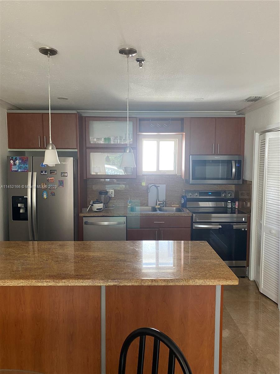 240 Southwest 15th Road, Unit 110 Miami, FL 33129 - Photo 5 of 17 a large kitchen with stainless steel appliances granite countertop a refrigerator a stove and a sink with wooden floor