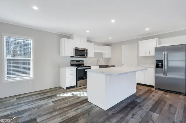 a kitchen with a refrigerator a stove top oven a sink and a center island