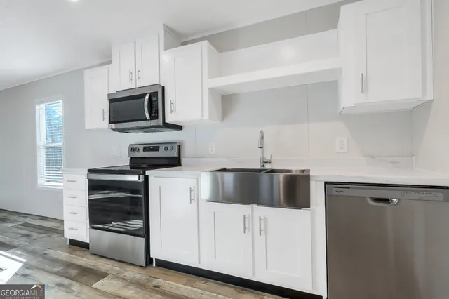 a kitchen with white cabinets and stainless steel appliances
