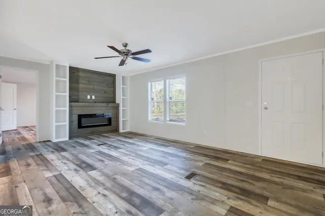 a view of empty room with a fireplace and fan