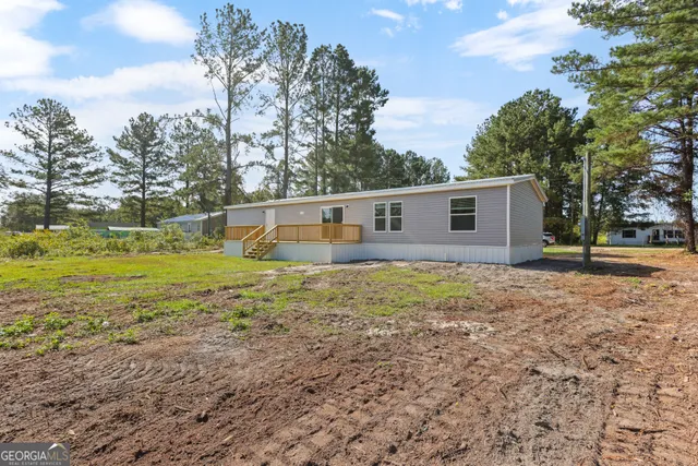 a view of a house with backyard and trees