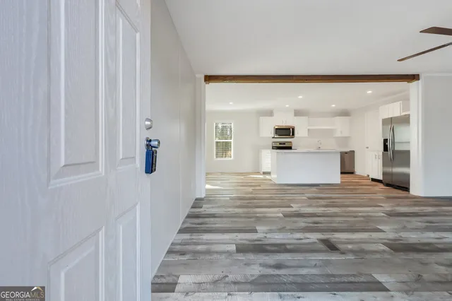 a view of a hallway with wooden floor and windows