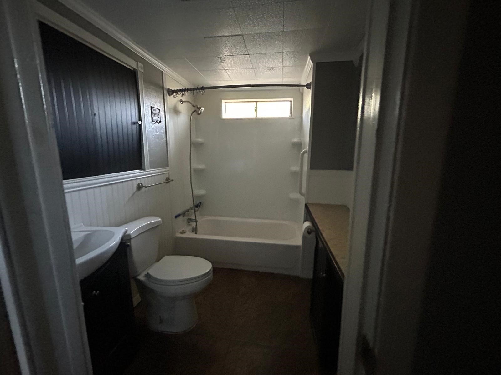 401 Billington Street Clute, TX 77531 - Photo 12 of 22 a bathroom with a granite countertop toilet a sink and bathtub