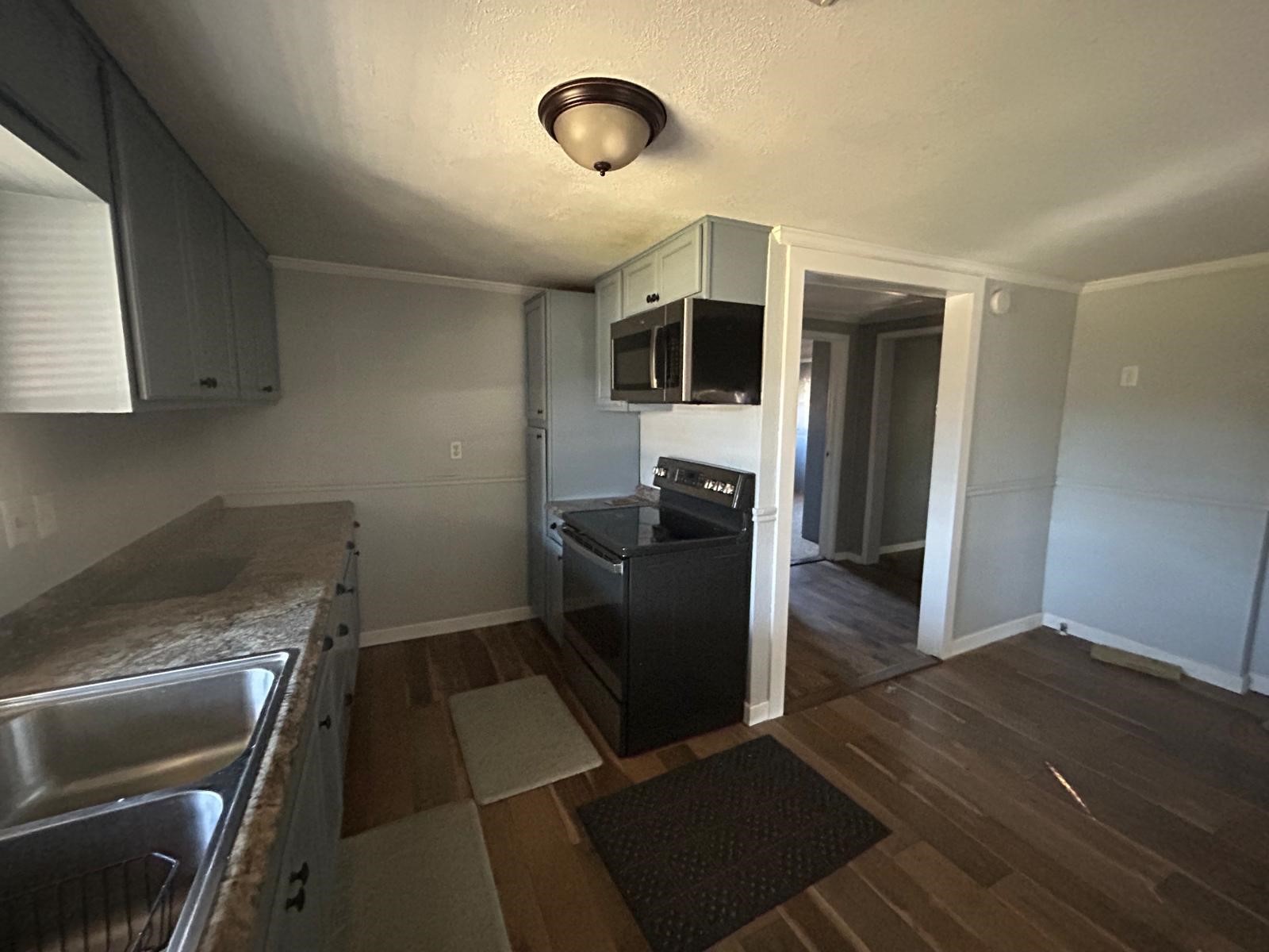 401 Billington Street Clute, TX 77531 - Photo 5 of 22 a kitchen with granite countertop cabinets and steel stainless steel appliances
