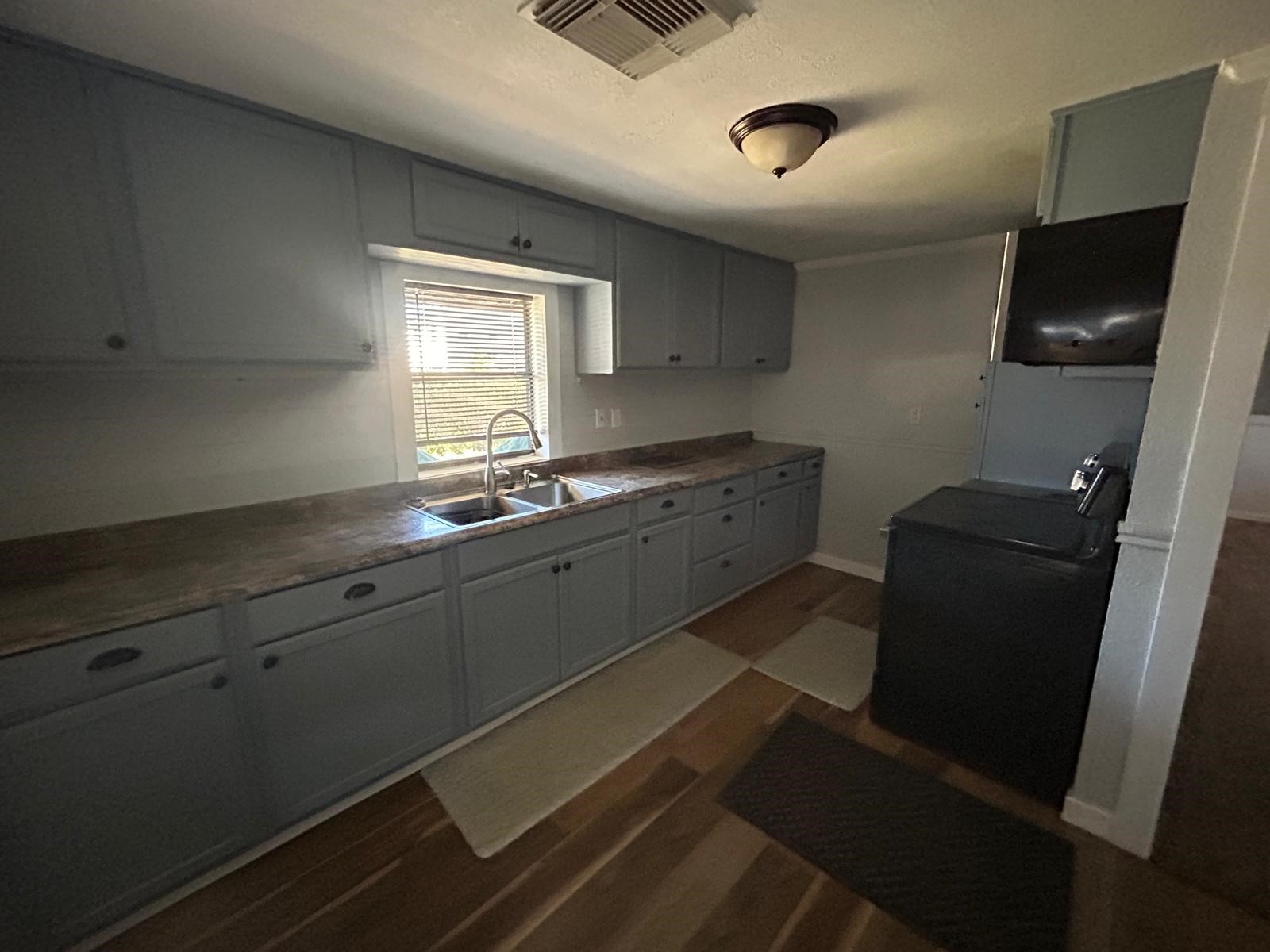 401 Billington Street Clute, TX 77531 - Photo 6 of 22 a kitchen with granite countertop a sink a stove and a refrigerator