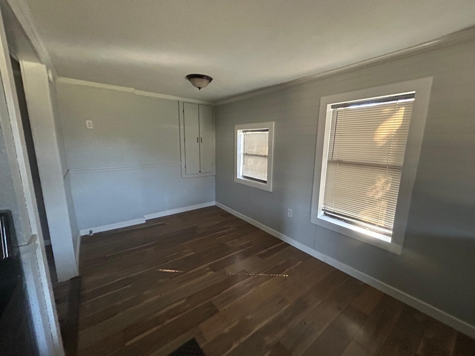 401 Billington Street Clute, TX 77531 - Photo 9 of 22 an empty room with wooden floor and windows