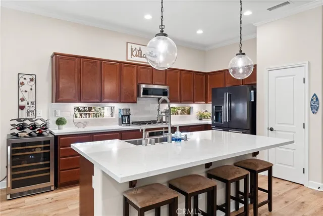 a kitchen with stainless steel appliances a table chairs stove and cabinets