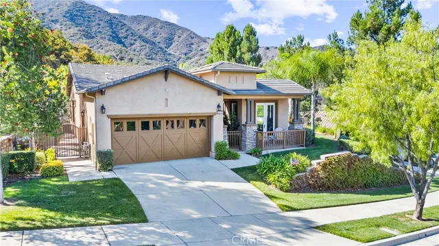 an aerial view of a house with a yard and large trees
