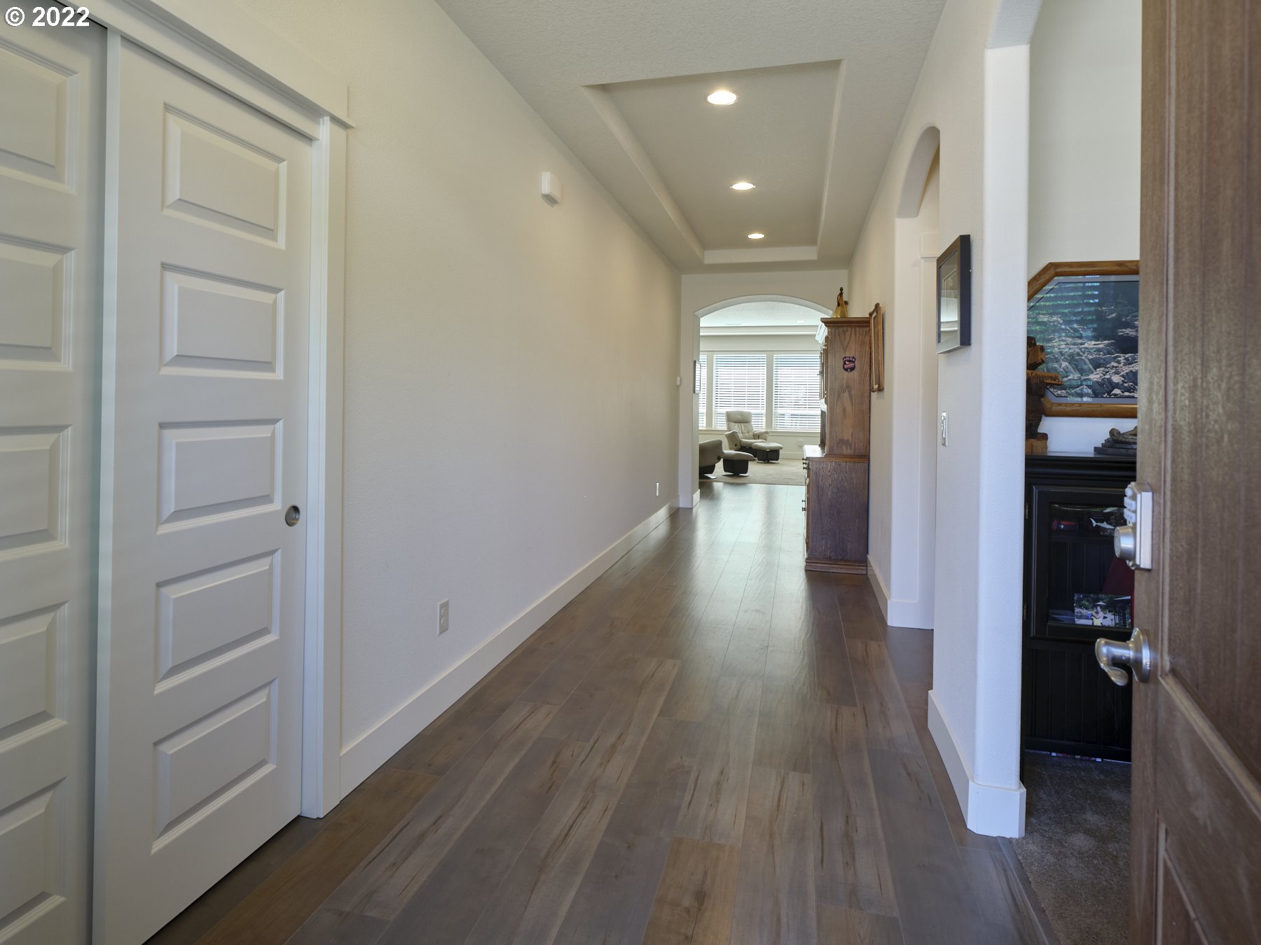 4911 South 19th Street Ridgefield, WA 98642 - Photo 6 of 26 a view of a hallway with wooden floor and a living room