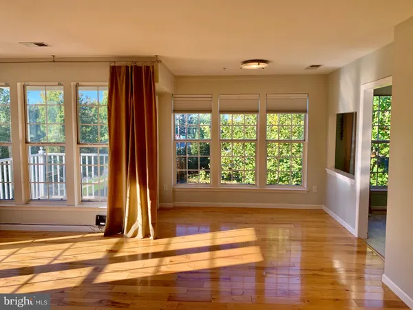 a view of empty room with wooden floor and a floor to ceiling window