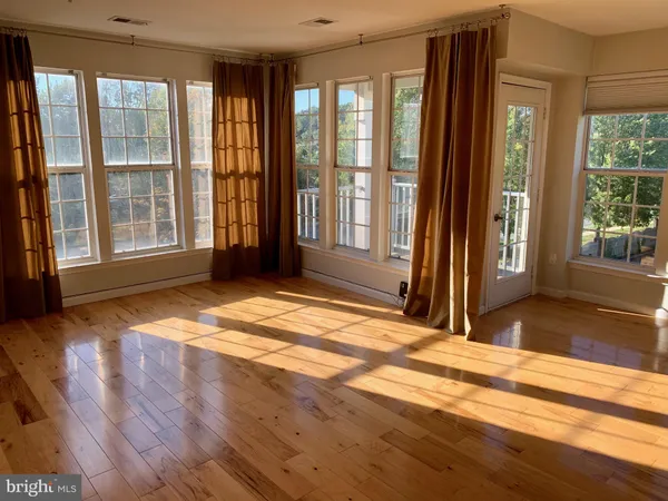 a view of a livingroom with wooden floor and a window