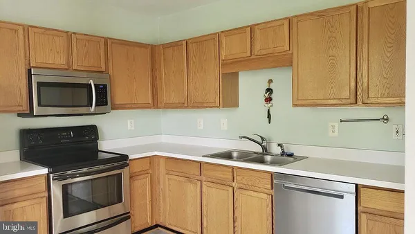 a kitchen with stainless steel appliances granite countertop white cabinets a sink and dishwasher