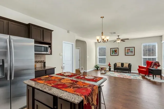 a outdoor kitchen with stainless steel appliances granite countertop a stove refrigerator and couch