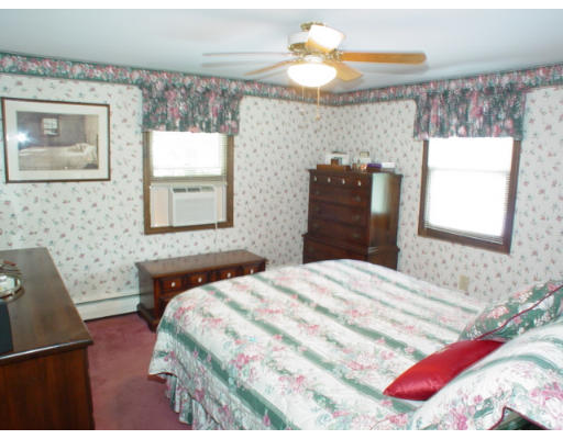 14 Middle Road Amesbury, MA 01913 - Photo 10 of 10 a bedroom with a bed and a chandelier