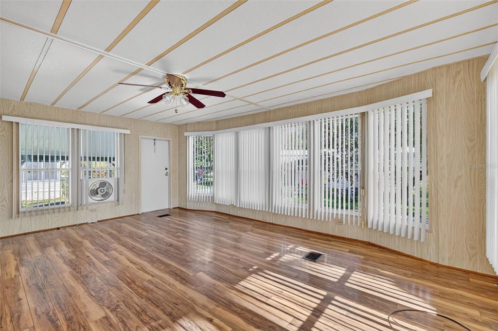 165 Shady Lane Eustis, FL 32726 - Photo 11 of 25 a view of a livingroom with wooden floor and a ceiling fan
