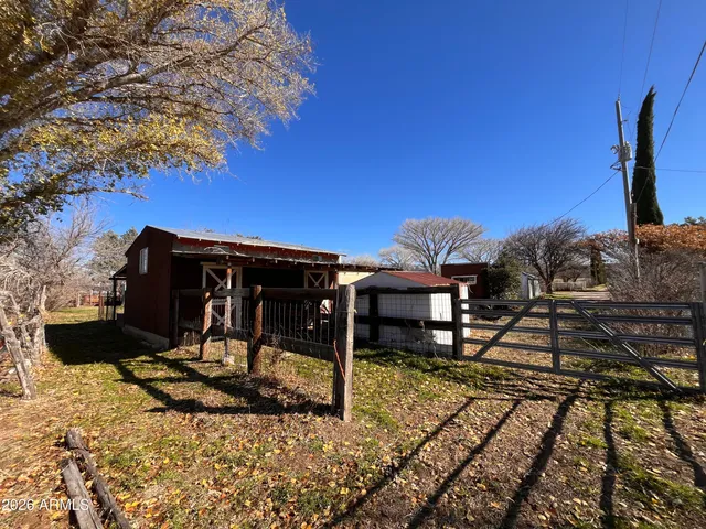 a view of a yard with plants and a bench