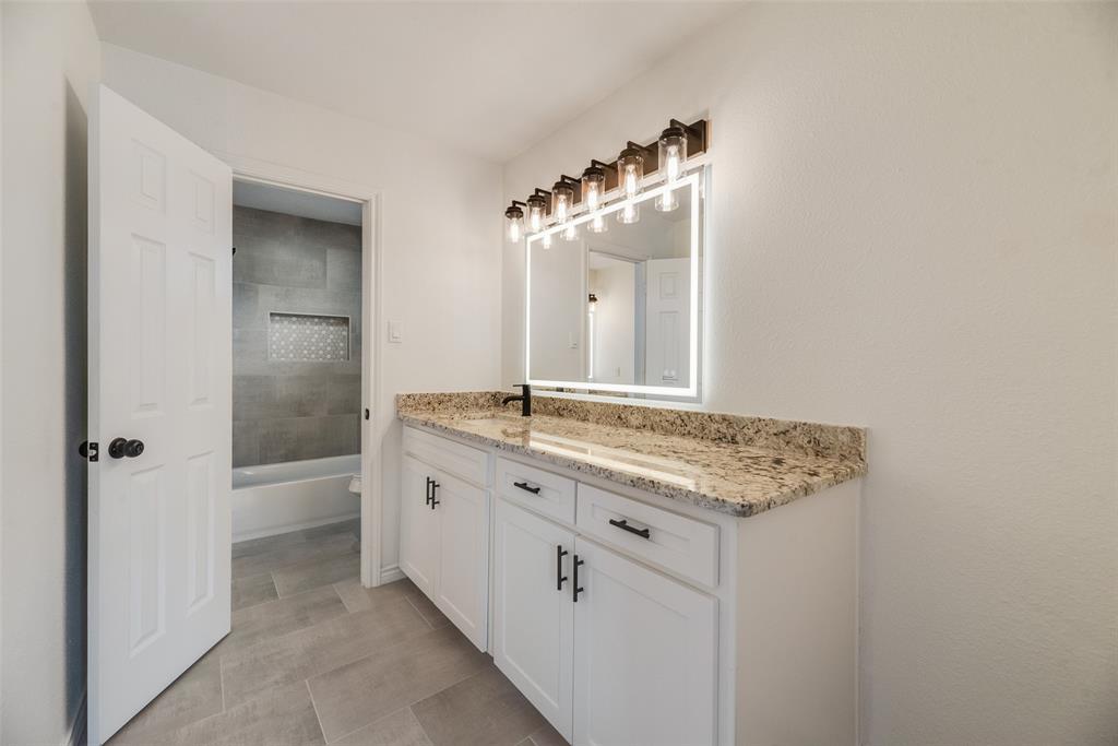 2720 Seeton Road Grand Prairie, TX 75054 - Photo 23 of 31 a bathroom with a granite countertop sink and a mirror