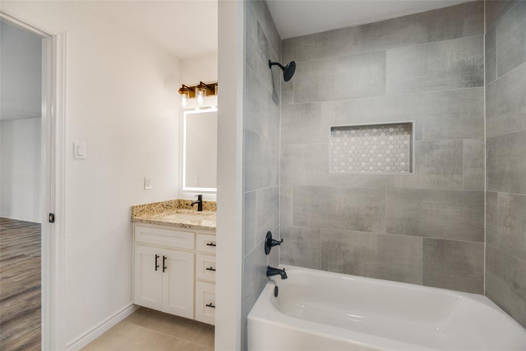 2720 Seeton Road Grand Prairie, TX 75054 - Photo 24 of 31 a bathroom with a granite countertop sink a toilet and shower