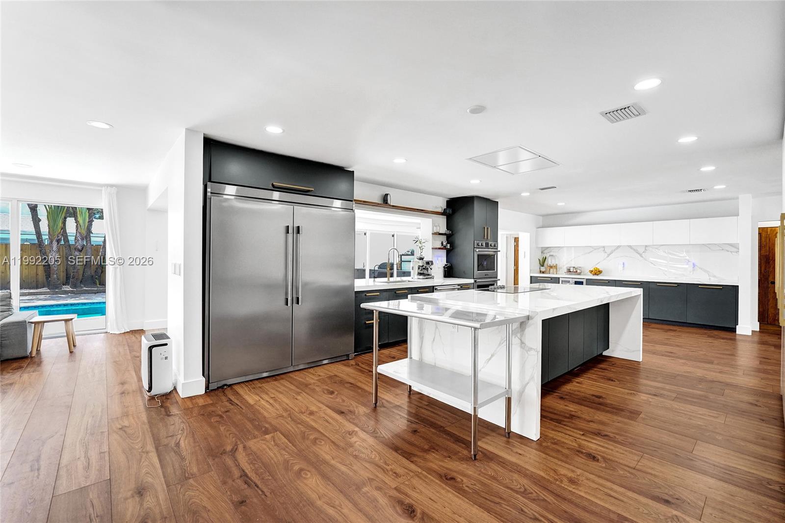3350 North 40th Street Hollywood, FL 33021 - Photo 21 of 100 a large kitchen with a center island wooden floor stainless steel appliances and windows