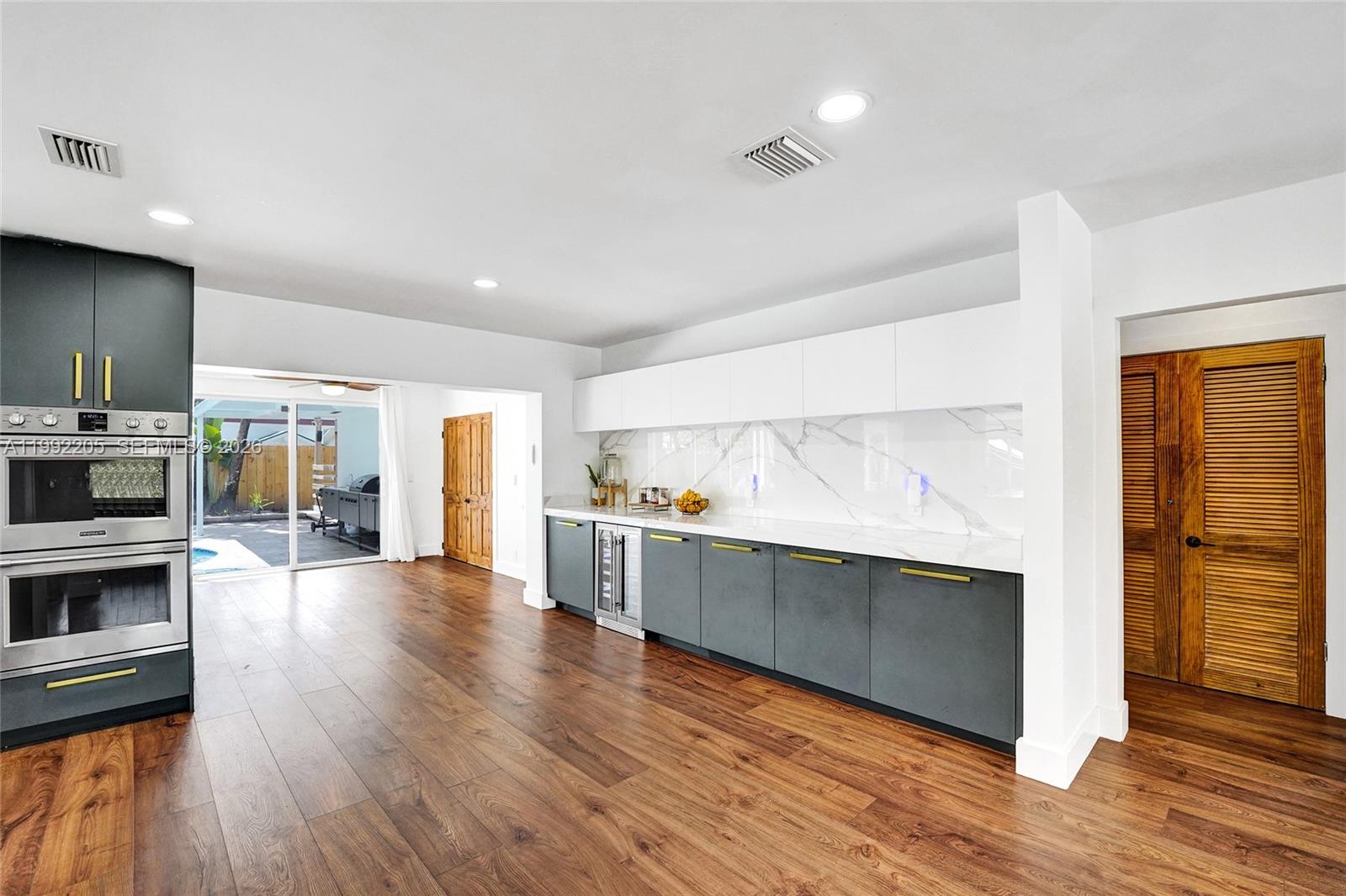 3350 North 40th Street Hollywood, FL 33021 - Photo 27 of 100 a large kitchen with a wooden floor and large stainless steel appliances