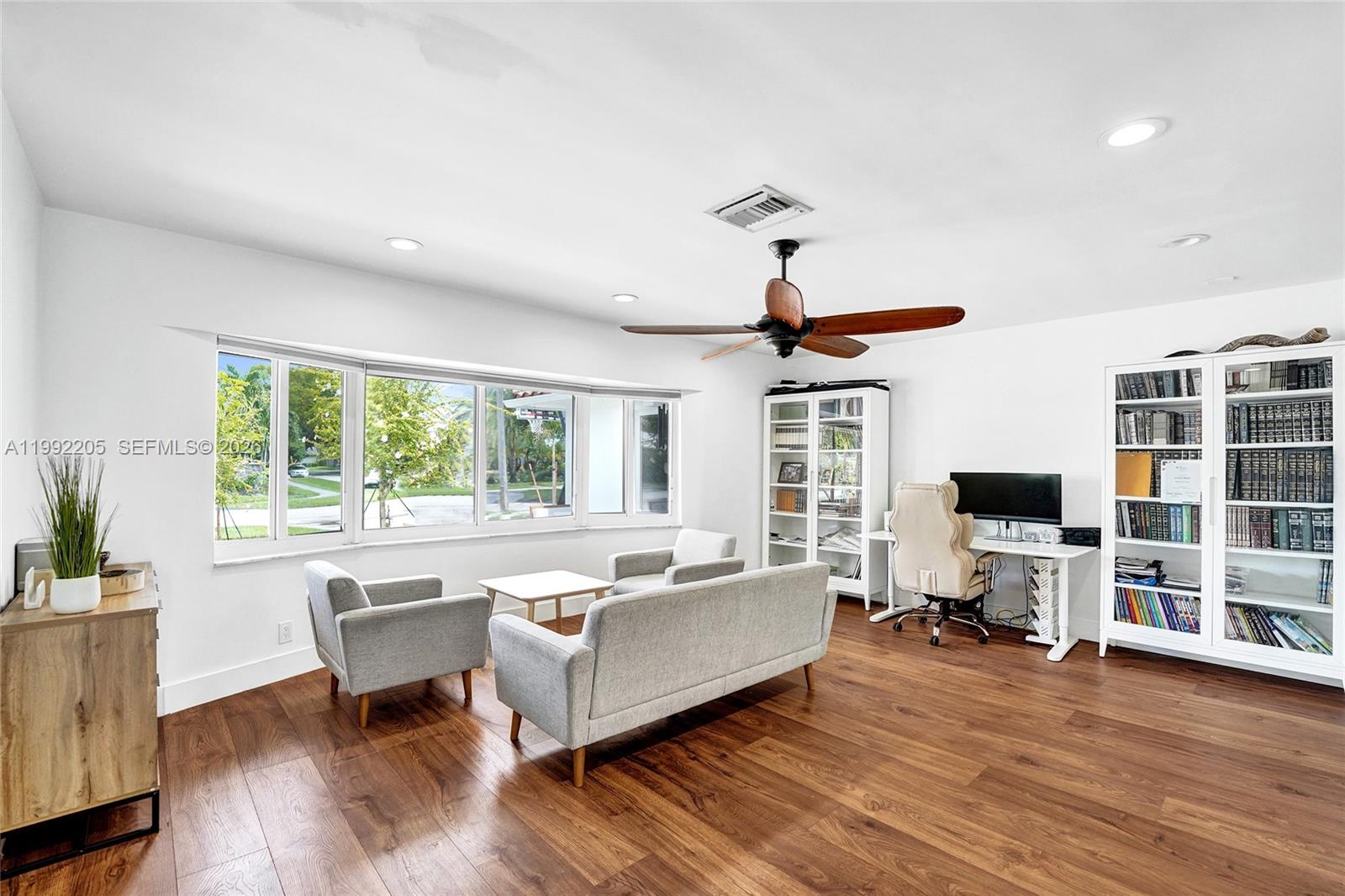 3350 North 40th Street Hollywood, FL 33021 - Photo 72 of 100 a living room with furniture floor to ceiling window hardwood floor and a flat screen tv
