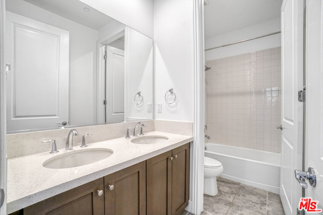 20705 West Chestnut Circle Porter Ranch, CA 91326 - Photo 25 of 35 a bathroom with a granite countertop sink toilet and shower