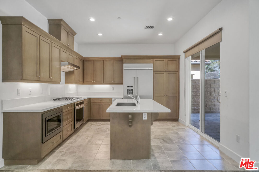 20705 West Chestnut Circle Porter Ranch, CA 91326 - Photo 8 of 35 a kitchen with stainless steel appliances granite countertop a sink stove and refrigerator