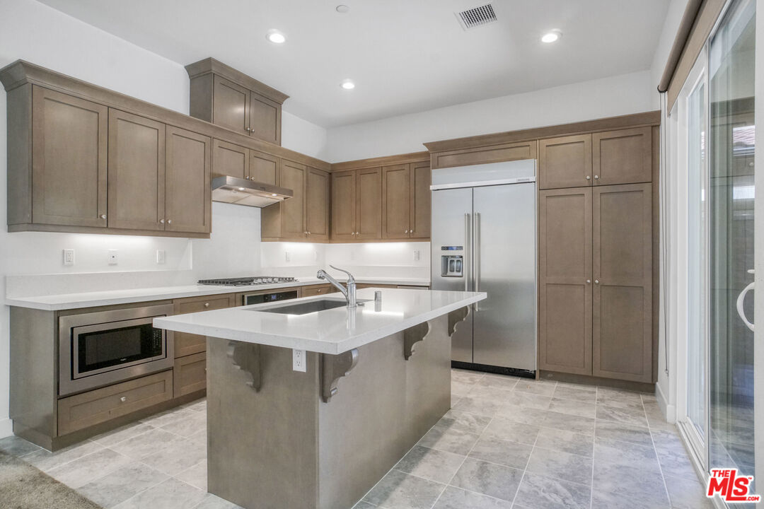 20705 West Chestnut Circle Porter Ranch, CA 91326 - Photo 9 of 35 a kitchen with stainless steel appliances granite countertop a sink stove and refrigerator