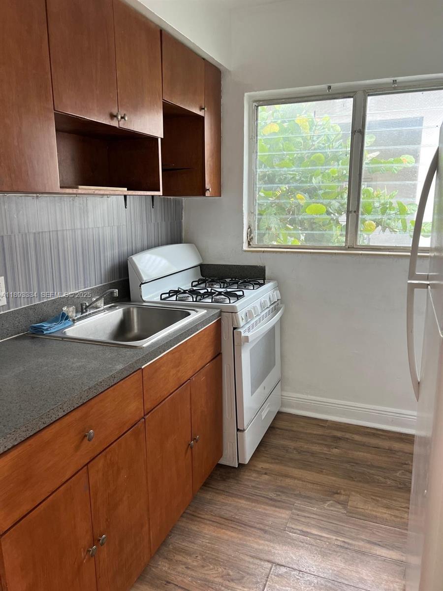 7333 Byron Avenue, Unit 7335 Miami Beach, FL 33141 - Photo 3 of 5 a kitchen with stainless steel appliances granite countertop a stove a sink and a microwave
