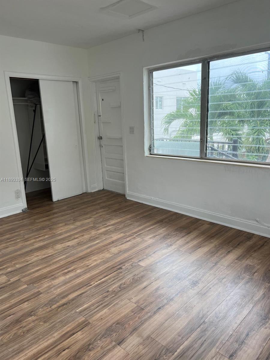 7333 Byron Avenue, Unit 7335 Miami Beach, FL 33141 - Photo 4 of 5 a view of an empty room with wooden floor and a window