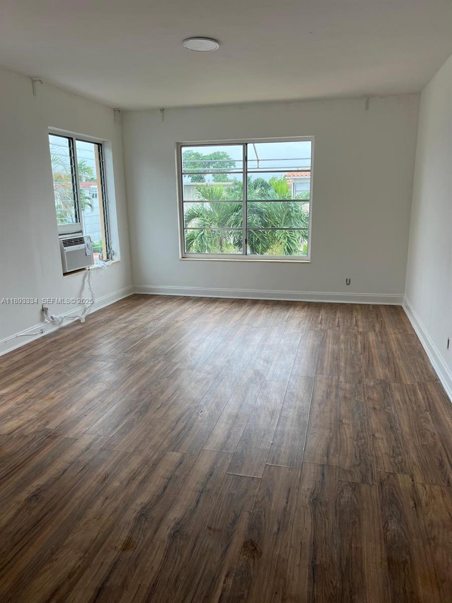 7333 Byron Avenue, Unit 7335 Miami Beach, FL 33141 - Photo 5 of 5 an empty room with wooden floor and windows