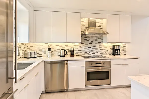 a kitchen with white cabinets and white appliances