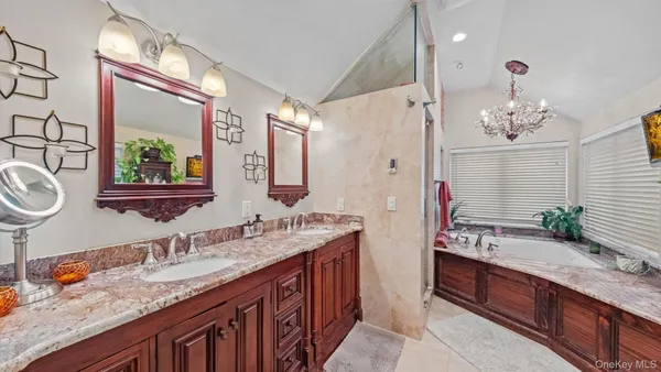 a bathroom with a granite countertop double vanity sink and a mirror