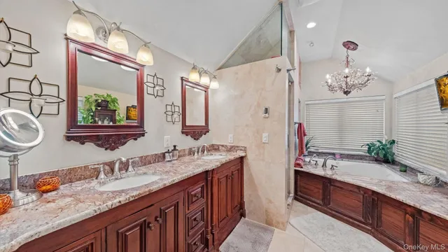 a bathroom with a granite countertop double vanity sink and a mirror