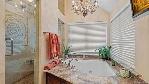 a bathroom with a granite countertop sink a mirror and shower