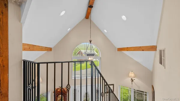 a view of a hallway with wooden floor and stairs