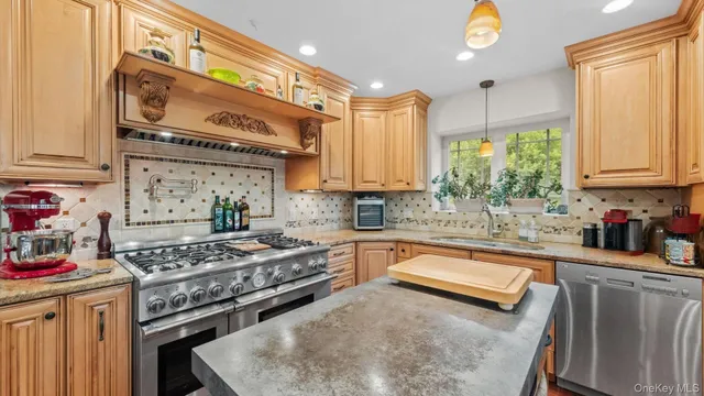 a kitchen with stainless steel appliances granite countertop a stove a sink and a microwave